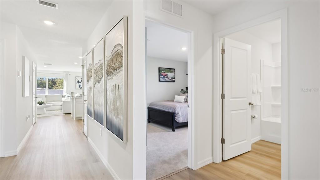 A hallway leads to a living area, a bedroom, and a bathroom with light flooring — 15014 CROSSHALL STREAM DRIVE, WIMAUMA, FL