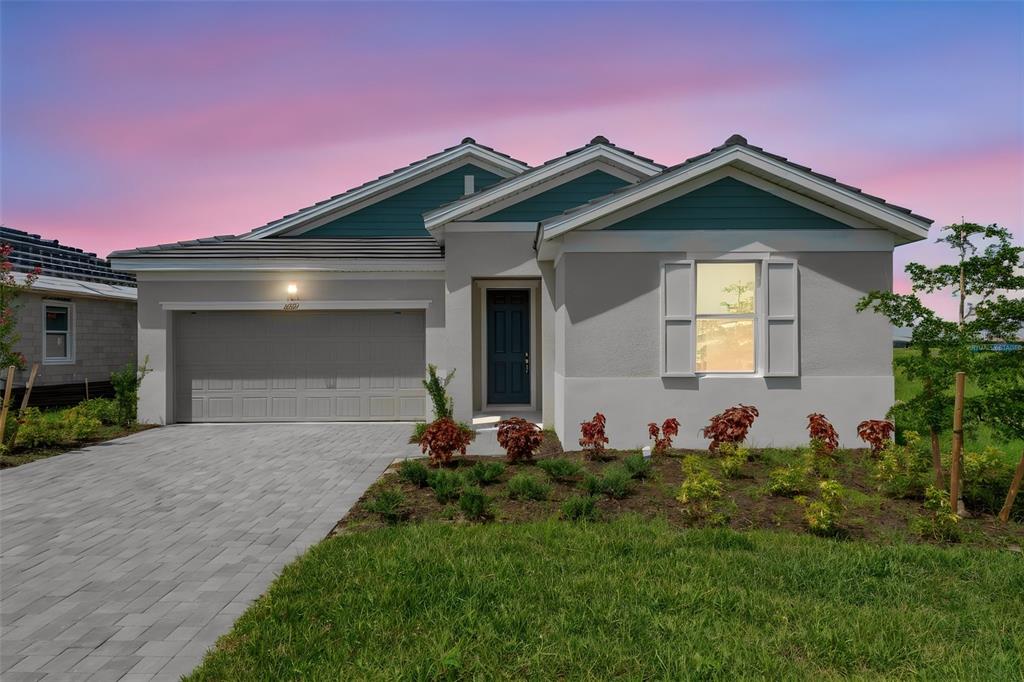 A single-story house with a gray stucco exterior, teal gables, and a paved driveway — 16930 SQUIRREL BRANCH LANE, ALVA, FL