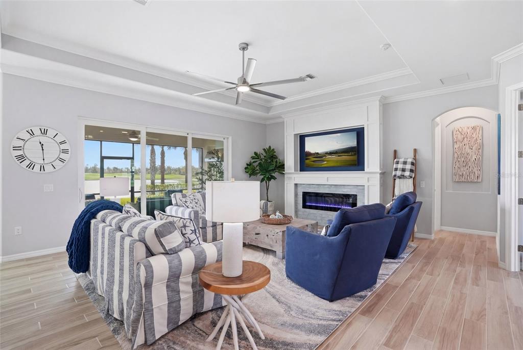 A living room features a fireplace, blue armchairs, a striped sofa, and a ceiling fan — 15073 RIVER BIRCH COURT, PUNTA GORDA, FL