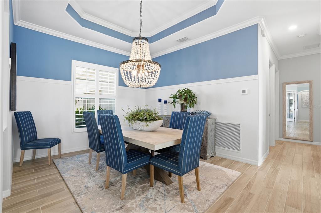A dining room features blue and white walls, a beaded chandelier, and blue striped chairs — 15073 RIVER BIRCH COURT, PUNTA GORDA, FL