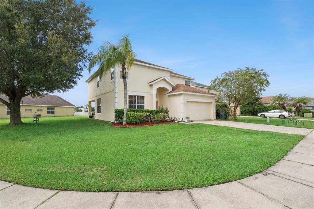 A two-story beige house with a two-car garage and a large front lawn — 3636 BRISTOL COVE LANE, ST CLOUD, FL