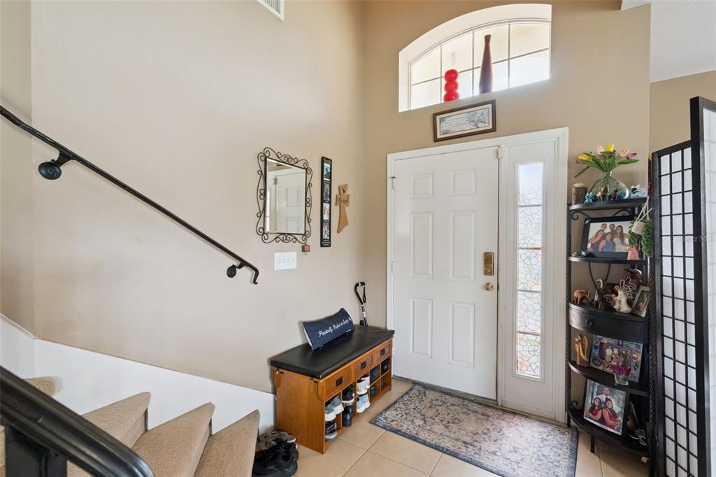 An entryway features a staircase, a white front door with a sidelight, and a shoe bench — 3636 BRISTOL COVE LANE, ST CLOUD, FL
