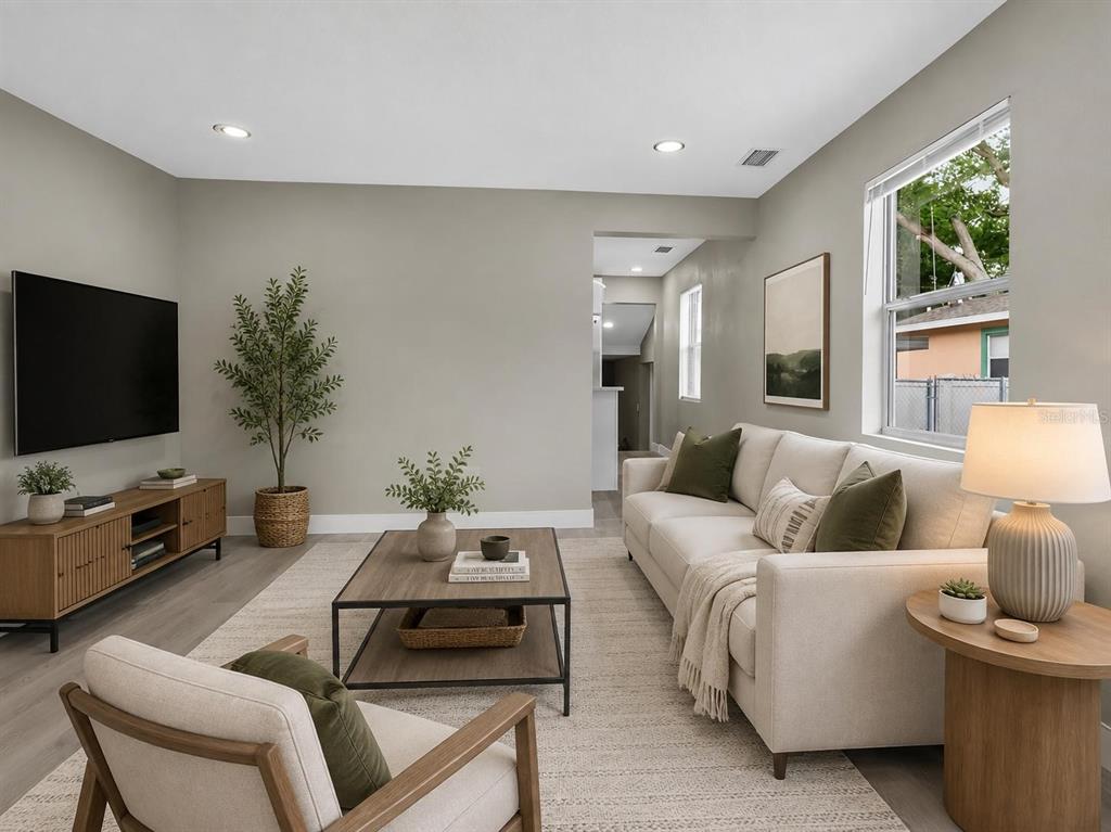 An empty room with gray walls, light wood-look flooring, and a window overlooking a yard — 1900 25TH STREET S, ST PETERSBURG, FL