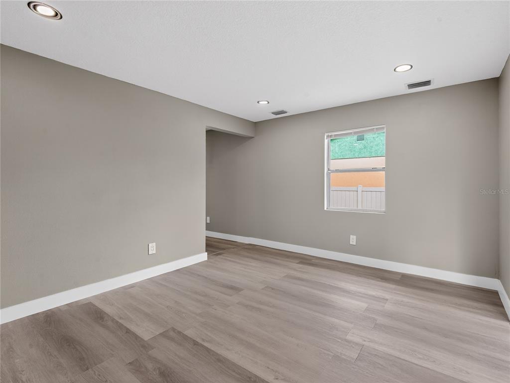 An entryway features light gray walls, wood-look flooring, a white front door, and two windows — 1900 25TH STREET S, ST PETERSBURG, FL