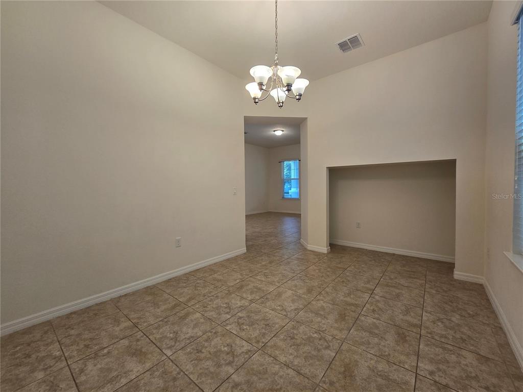 A dining room with tile flooring, a chandelier, and a recessed wall niche — 9349 TYRELLA PINE TRAIL, WINTER GARDEN, FL