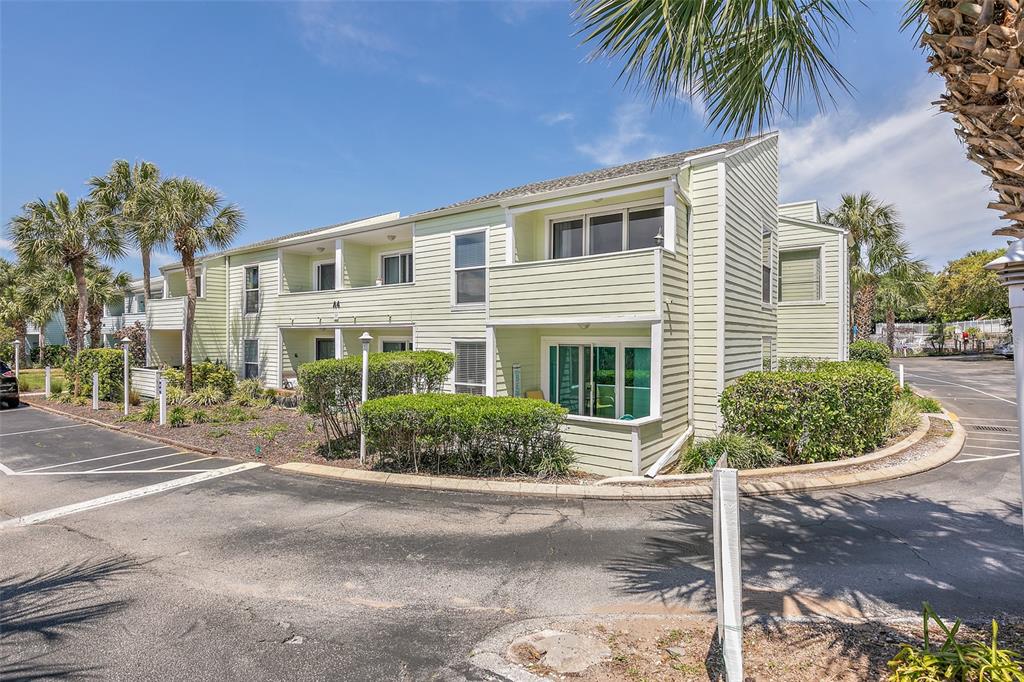 A two-story, light green building with balconies and palm trees sits beside a parking lot — 6300 A1A S UNIT A41U, ST AUGUSTINE, FL