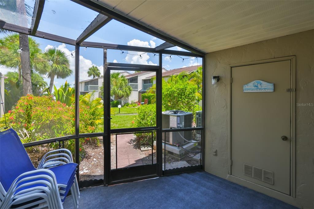 A screened-in patio with blue chairs, a beige door, and a view of the outdoors — 1028 APOLLO BEACH BOULEVARD UNIT 8, APOLLO BEACH, FL