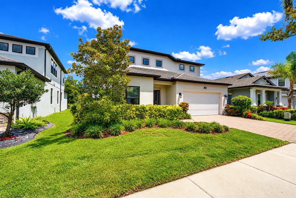 A two-story suburban house with a white exterior, a garage, and a landscaped front yard — 1621 LEAF FLOWER LANE, LUTZ, FL
