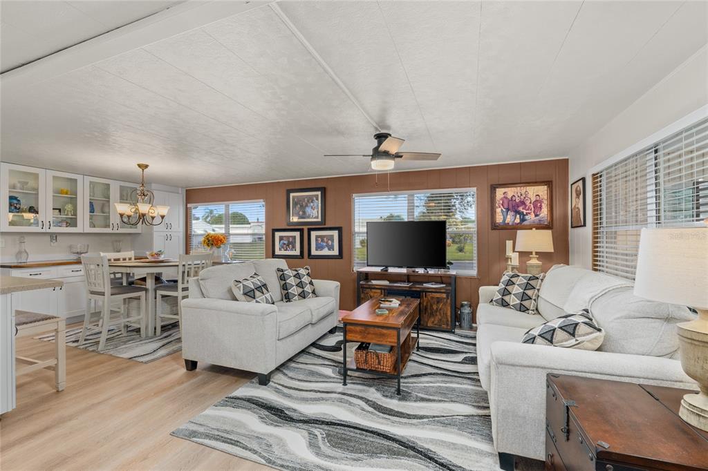 A bedroom features a floral bedspread, a large dresser with a television, and a ceiling fan — 288 SALEM AVENUE UNIT 3, PALM HARBOR, FL