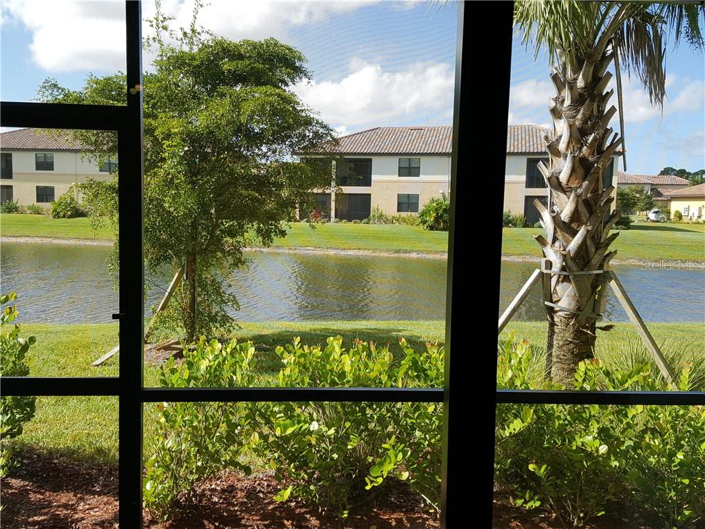 A view of a pond and apartment buildings seen through a screened-in porch — 20170 LAGENTE CIRCLE, VENICE, FL