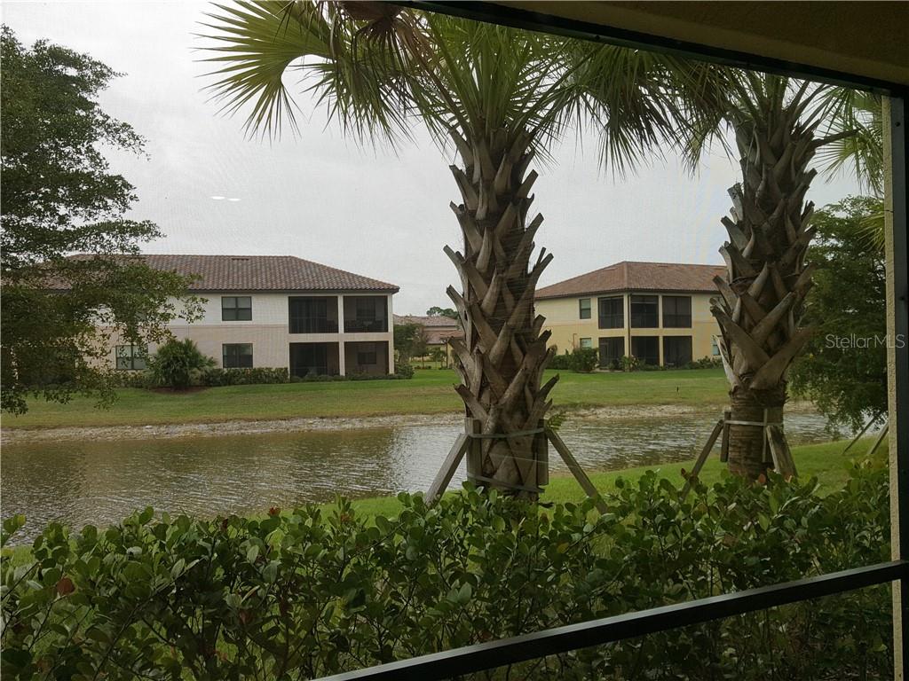A view of a pond and apartment buildings from a screened-in patio — 20170 LAGENTE CIRCLE, VENICE, FL