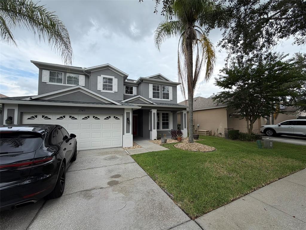 A two-story gray house with a white garage door and a palm tree in front — 2549 BALFORN TOWER WAY, WINTER GARDEN, FL