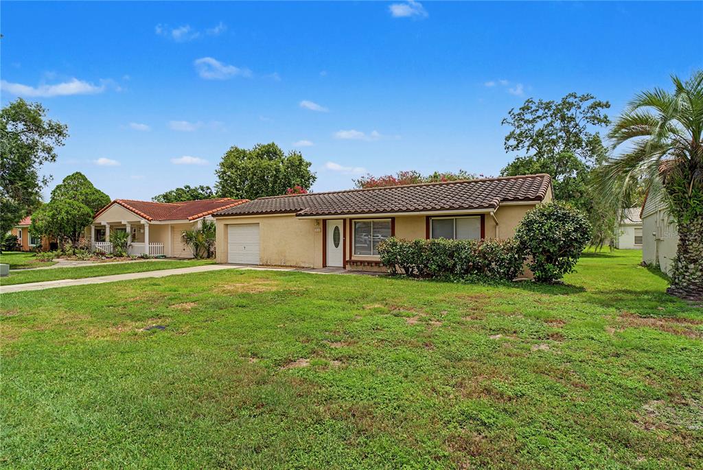 A white front door and two wicker chairs sit on a brick patio — 10145 BLUFF COURT, ORLANDO, FL