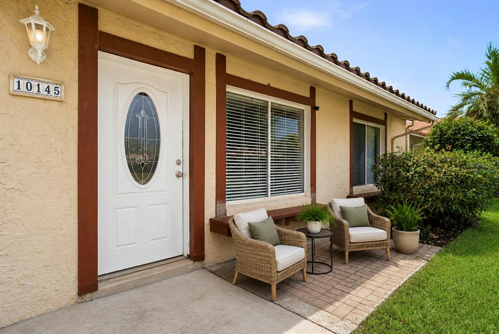 The exterior of a house features a white front door, windows with shutters, and brick pavers — 10145 BLUFF COURT, ORLANDO, FL