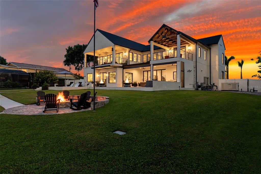 A two-story modern house with a fire pit and patio at sunset — 692 GLADWIN AVENUE, FERN PARK, FL