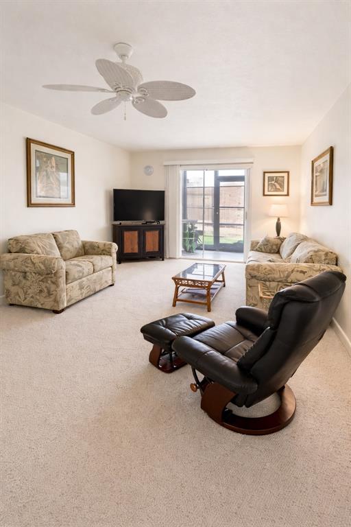 A living room features a ceiling fan, two patterned sofas, and a dark leather recliner — 1640 JUNO TRAIL UNIT 103F, ASTOR, FL