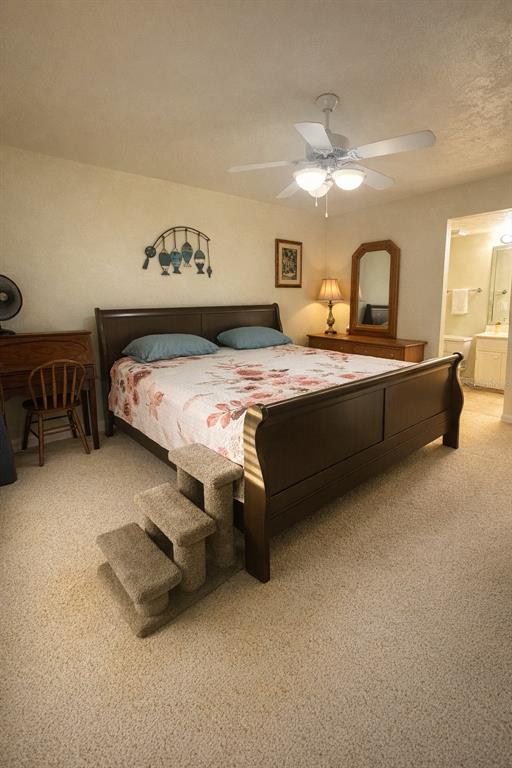 A bedroom features a sleigh bed, pet stairs, a ceiling fan, and an attached bathroom — 1640 JUNO TRAIL UNIT 103F, ASTOR, FL