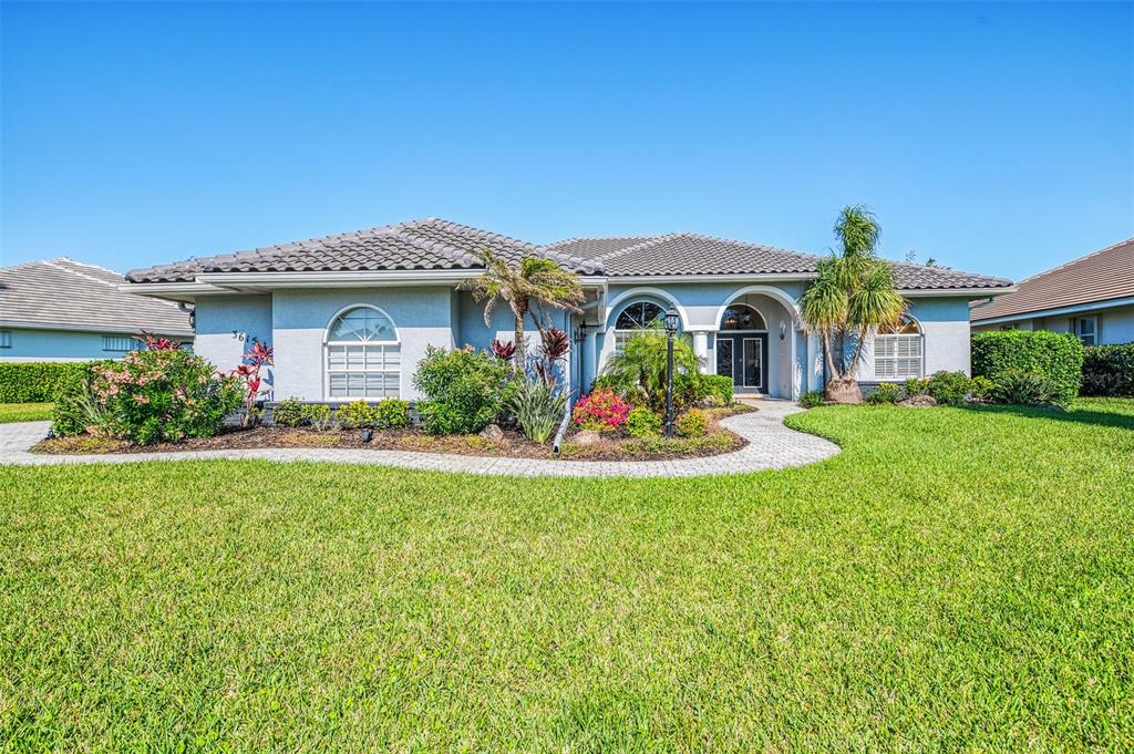 A single-story house with a tiled roof, arched entryway, and landscaped front yard — 3615 PENNYROYAL ROAD, PORT CHARLOTTE, FL