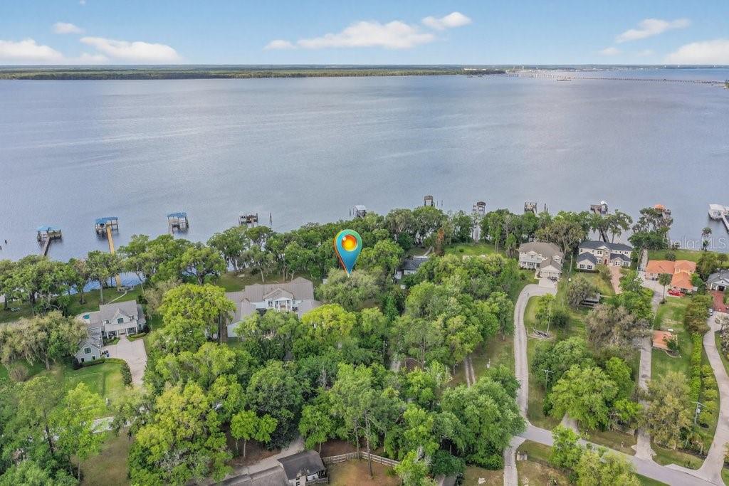 An aerial view shows a waterfront property with a large house surrounded by dense trees — 6373 JACK WRIGHT ISLAND ROAD, ST AUGUSTINE, FL