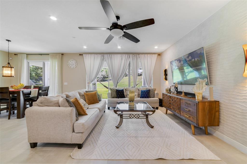 A living room features a beige sofa, a glass coffee table, and a wooden media console — 1970 STANDING ROCK CIRCLE, OAKLAND, FL