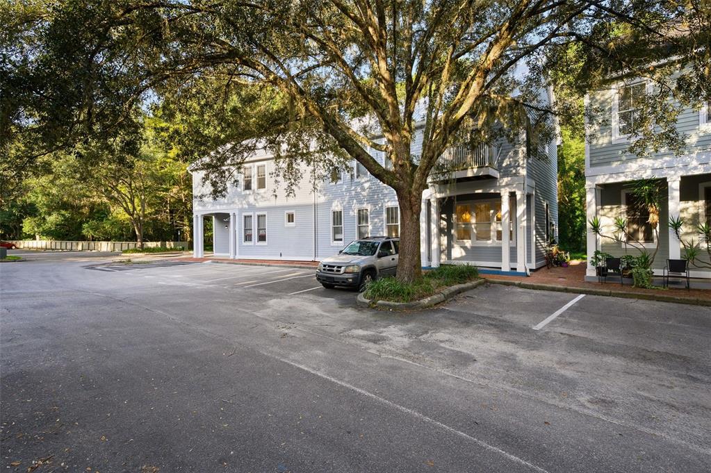 A light blue multi-story building with a parking lot and a large tree in front — 5214 SW 91ST WAY, GAINESVILLE, FL