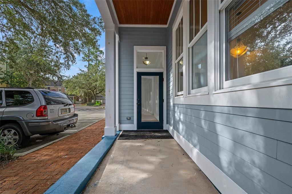 A covered porch with a blue door, light blue siding, and a brick walkway — 5214 SW 91ST WAY, GAINESVILLE, FL