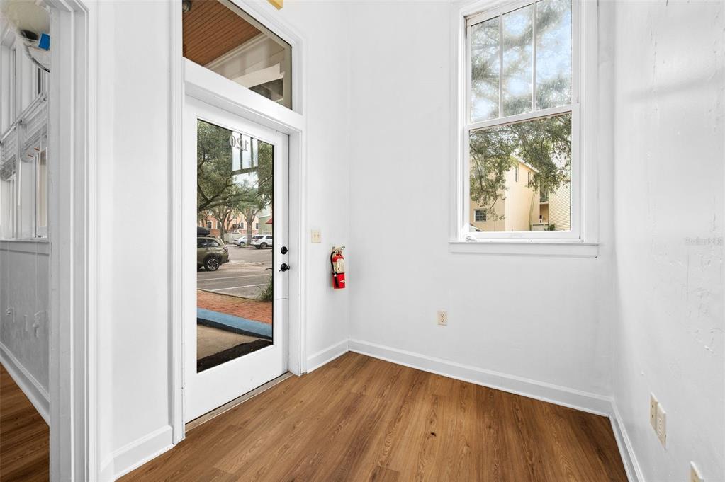An entryway with wood-look flooring, white walls, a glass-paneled door, and a window — 5214 SW 91ST WAY, GAINESVILLE, FL