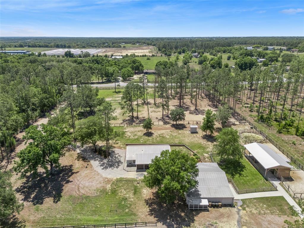 An aerial view shows a house, a detached garage, and a barn on a wooded lot — 20701 COUNTY ROAD 44A, EUSTIS, FL