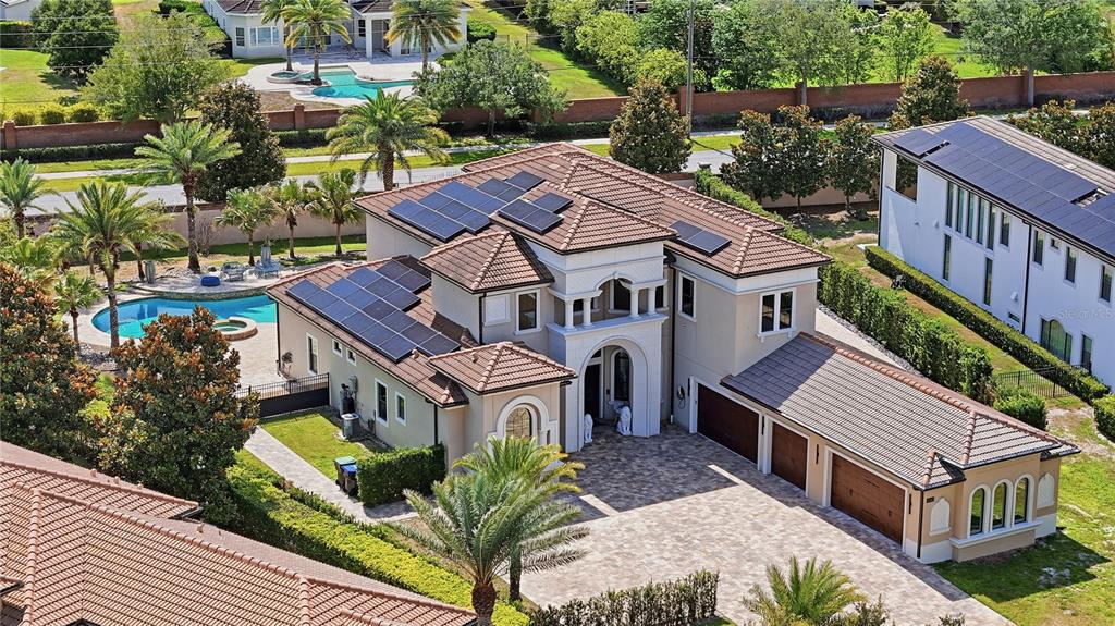 An aerial view of a two-story house with a tile roof, solar panels, and pool — 4303 ISABELLA CIRCLE, WINDERMERE, FL