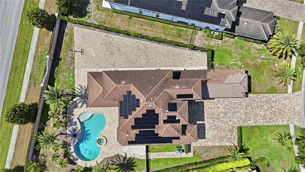 An aerial view shows a house with solar panels, a swimming pool, and stone-paved driveways — 4303 ISABELLA CIRCLE, WINDERMERE, FL