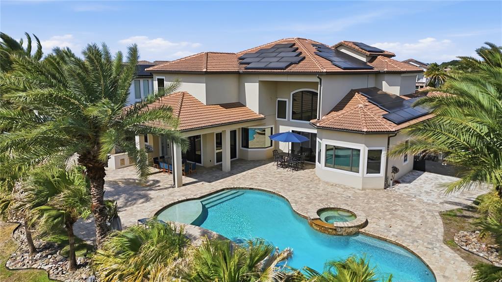 An aerial view of a two-story house with a pool, patio, and solar roof panels — 4303 ISABELLA CIRCLE, WINDERMERE, FL