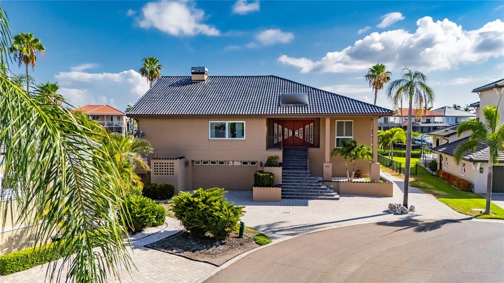 A two-story tan house with a dark tile roof and a paved driveway — 903 CAPRICCIO LANE, APOLLO BEACH, FL