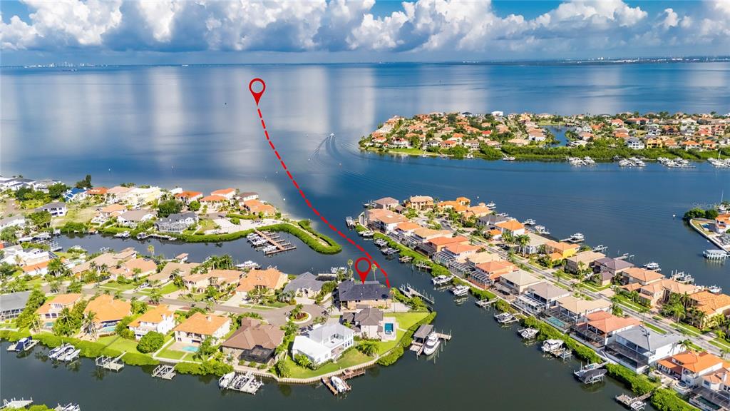 Aerial view of waterfront houses with private docks along a canal leading to a bay — 903 CAPRICCIO LANE, APOLLO BEACH, FL