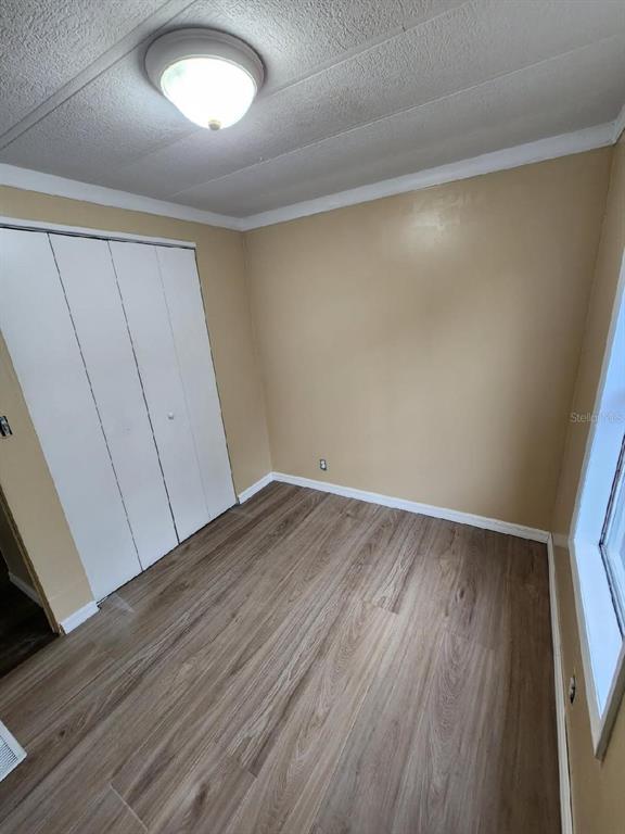 A small bedroom features light-colored walls, wood-look flooring, a white closet, and a ceiling light — 5010, 5040, 5080, & 5120 S BARKER POINT, LECANTO, FL