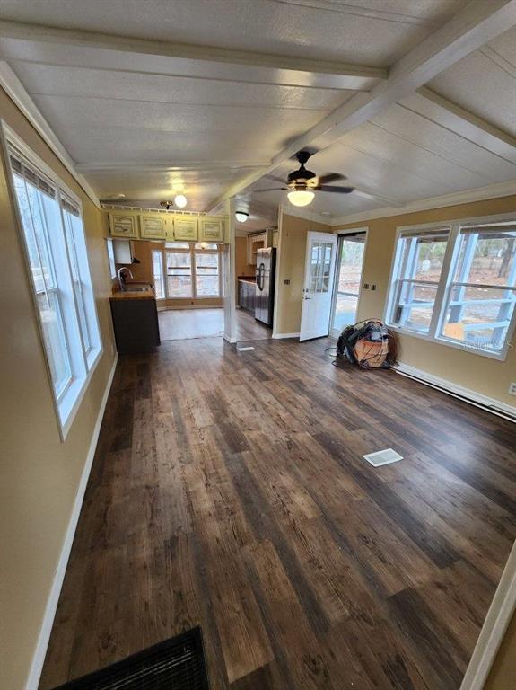 A living room with wood-look flooring, a ceiling fan, and an adjacent kitchen area — 5010, 5040, 5080, & 5120 S BARKER POINT, LECANTO, FL
