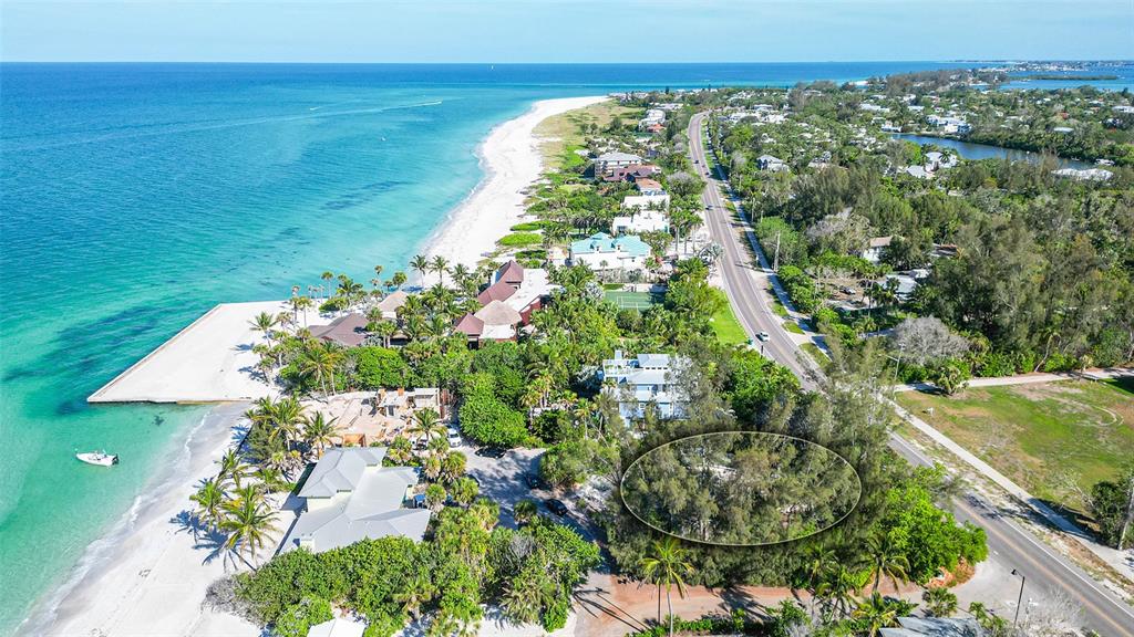 An aerial view of a coastal property featuring a beach, road, and a wooded lot — 6605 GULFSIDE ROAD, LONGBOAT KEY, FL