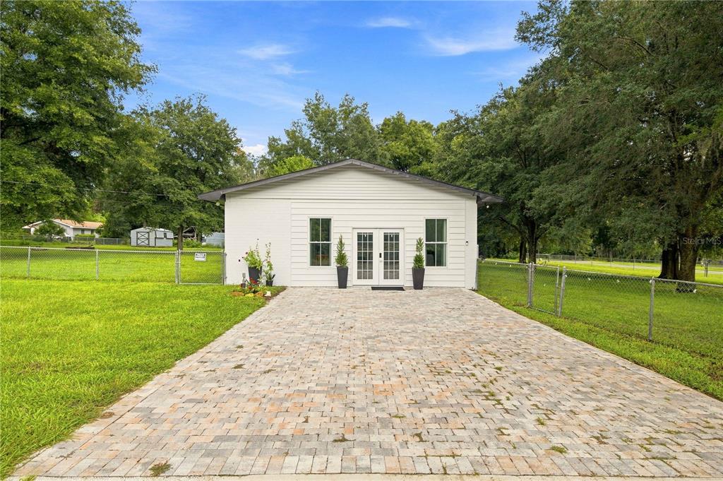A white, single-story building with a paved driveway and double-door entrance sits on a lawn — 455 SW 73RD STREET ROAD, OCALA, FL