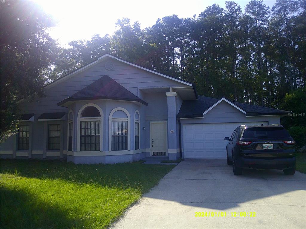 A single-story house with a light blue exterior, a bay window, and an attached garage — 818 VERMONT WOODS LANE, ORLANDO, FL