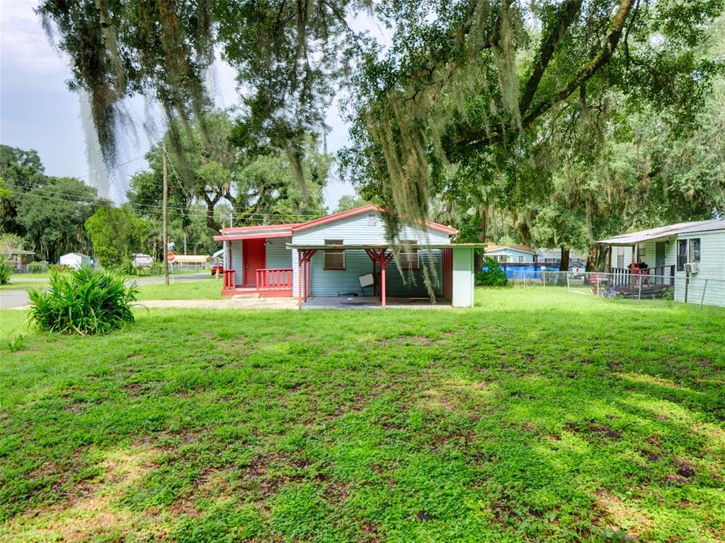 A light blue single-story house with a red porch and an attached carport — 813 NW 5TH STREET, WEBSTER, FL