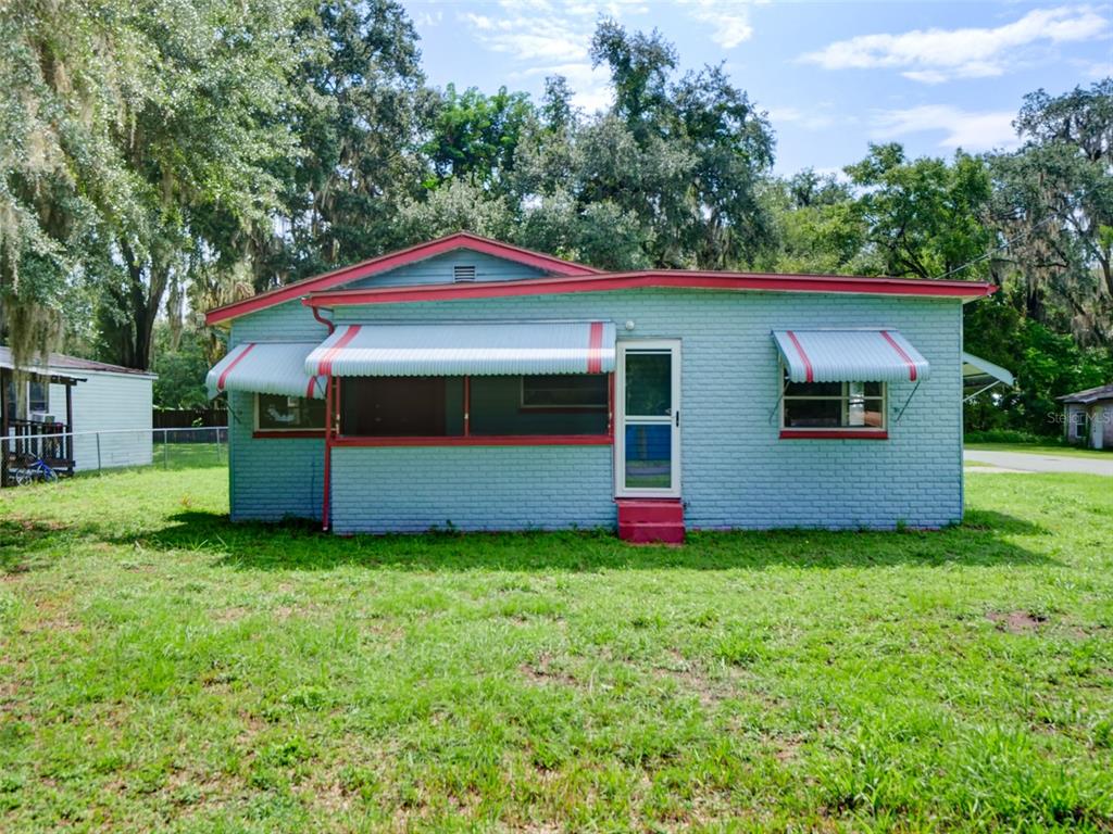 A kitchen features wood cabinets, a black refrigerator, a black stove, and light countertops — 813 NW 5TH STREET, WEBSTER, FL
