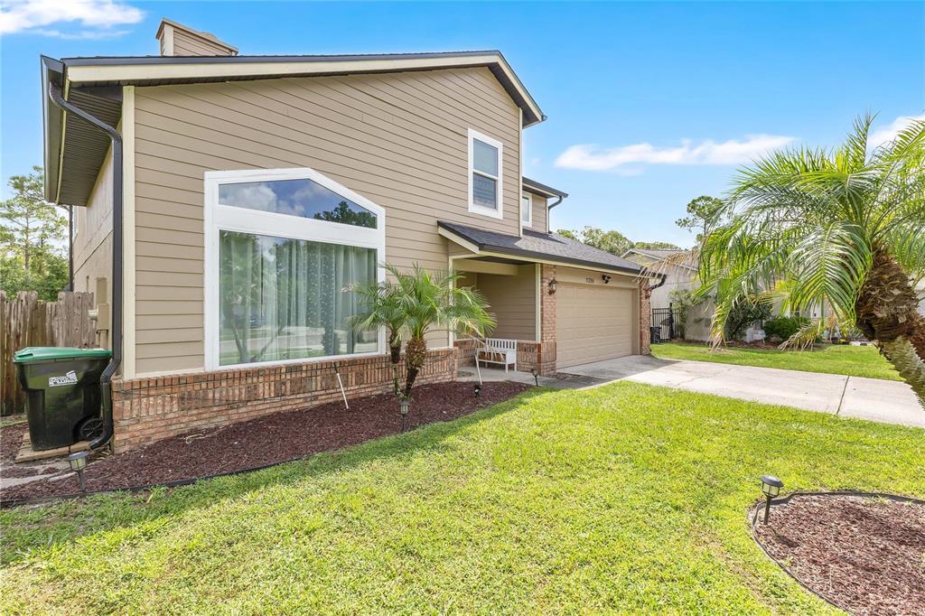 A two-story house with tan siding, a brick base, and a two-car garage — 11296 CYPRESS LEAF DRIVE, ORLANDO, FL