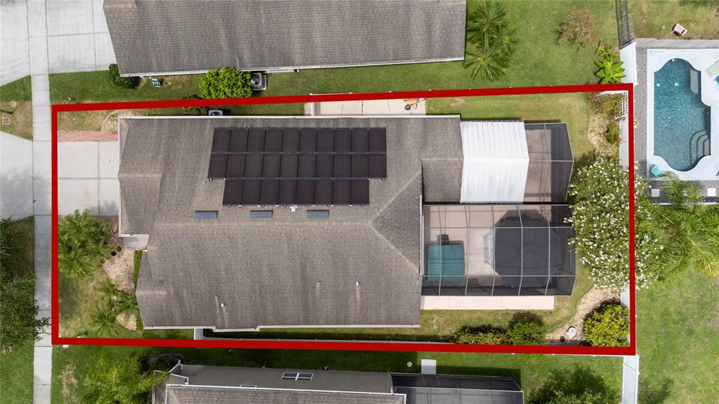 An aerial view shows a house with solar panels on the roof and a screened-in patio — 14617 KEELFORD WAY, ORLANDO, FL