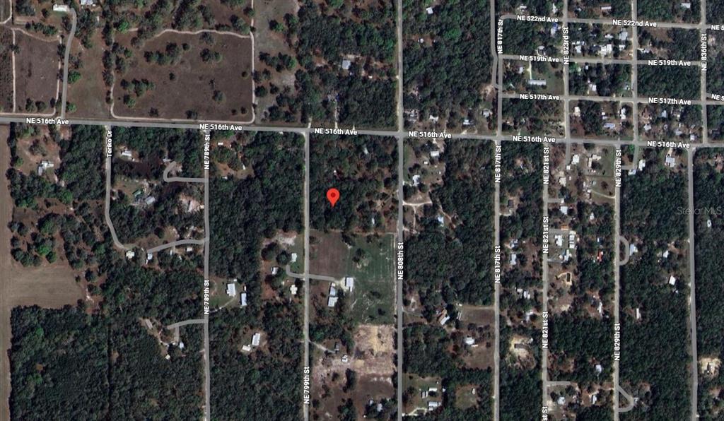 An aerial map view shows a red pin marking a wooded lot near residential streets — NE 799TH STREET, OLD TOWN, FL