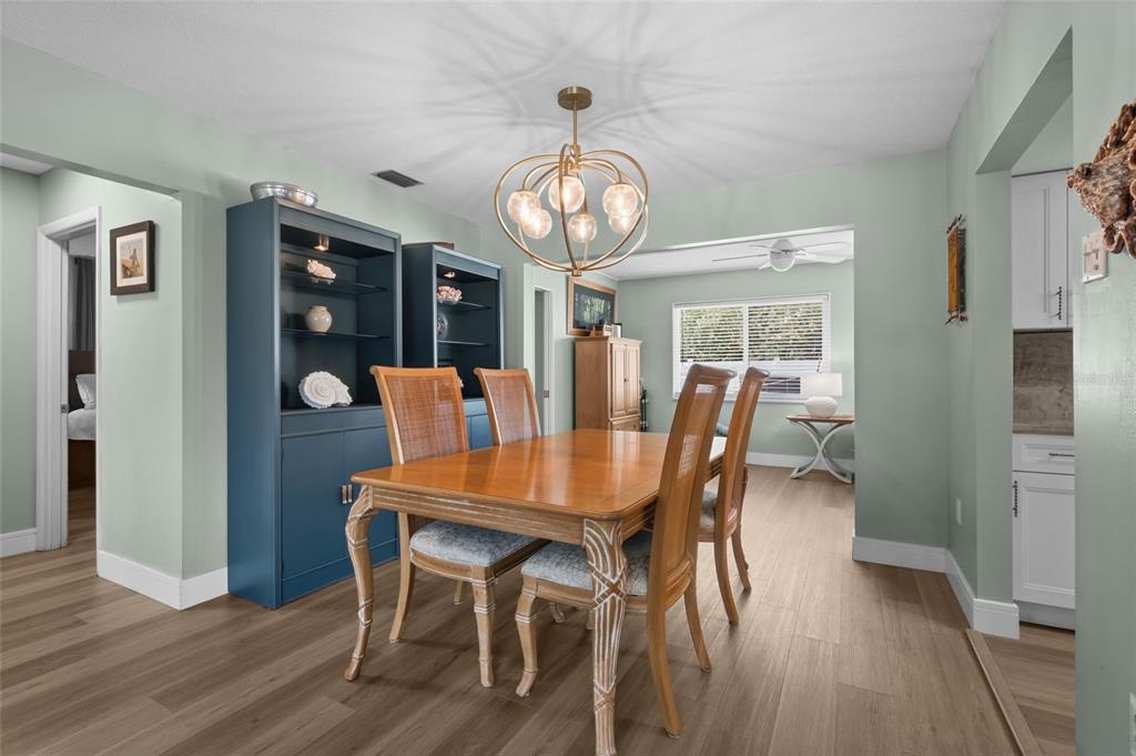 A dining room features a wooden table, four chairs, a blue cabinet, and a chandelier — 3274 SAVAGE ROAD, SARASOTA, FL