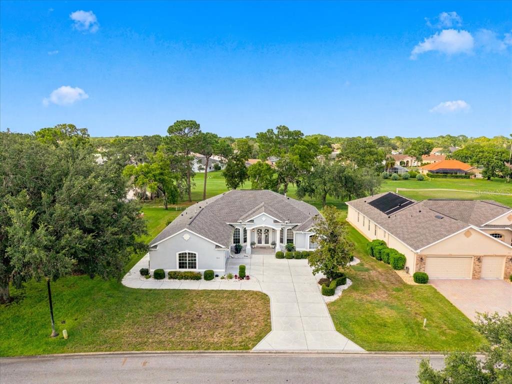 An aerial view of a single-story house with a gray roof and concrete driveway — 9251 GRAND CYPRESS DRIVE, WEEKI WACHEE, FL