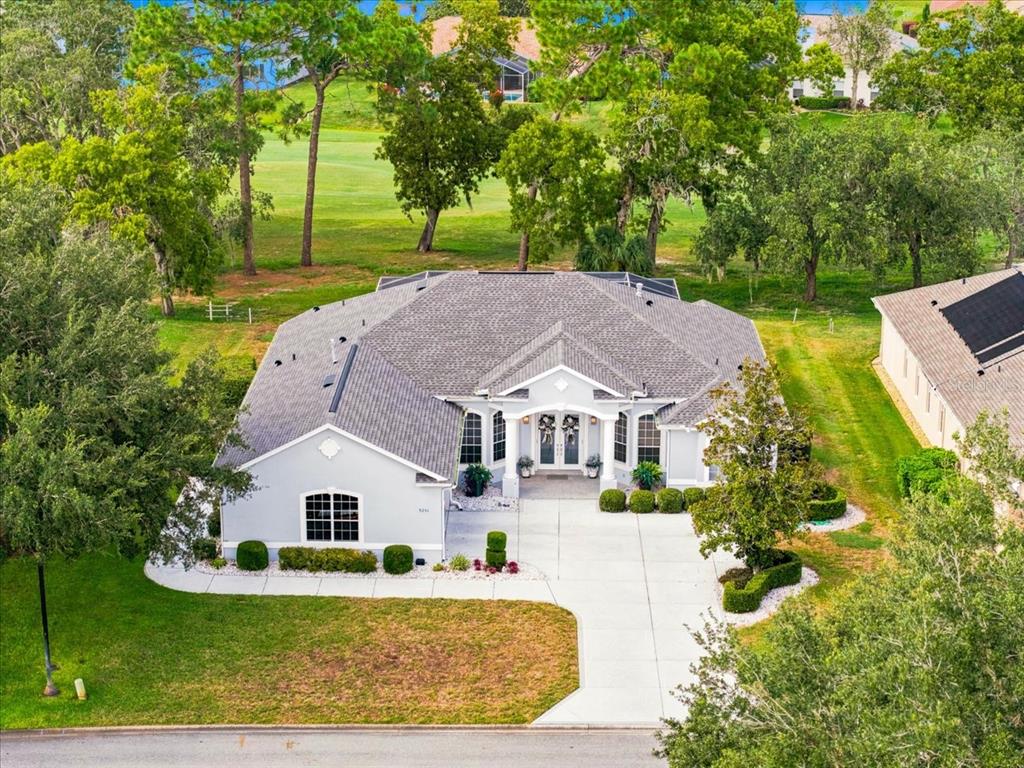 An aerial view of a single-story house with a gray roof and concrete driveway — 9251 GRAND CYPRESS DRIVE, WEEKI WACHEE, FL