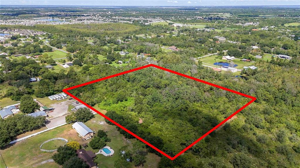 An aerial view shows a rectangular plot of land outlined in red amidst wooded surroundings — 0 EDSEL AVENUE, ST CLOUD, FL