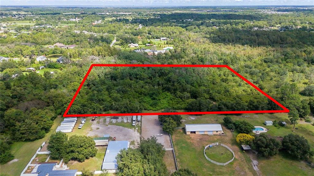 An aerial view shows a rectangular plot of land outlined in red behind several buildings — 0 EDSEL AVENUE, ST CLOUD, FL