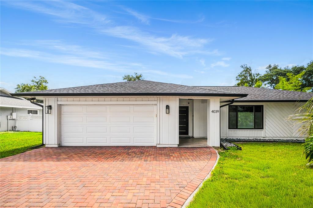 A single-story house with a white exterior, a brick driveway, and a two-car garage — 4039 COOL WATER COURT, WINTER PARK, FL