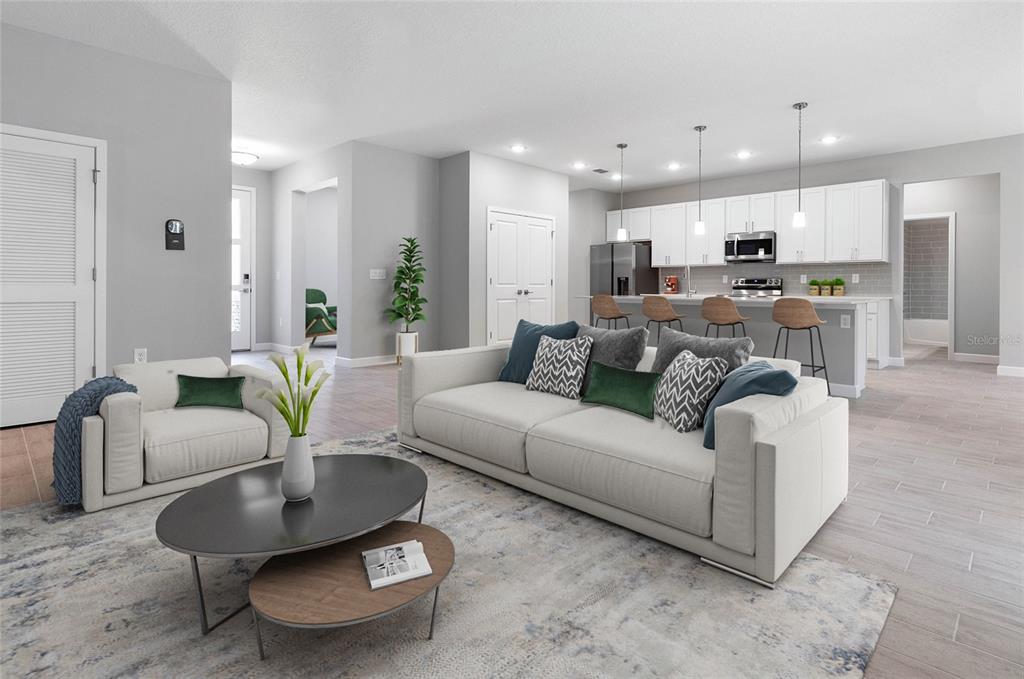 A modern living room with a white sofa and kitchen island in an open floor plan — 13 SW 34TH PLACE, CAPE CORAL, FL